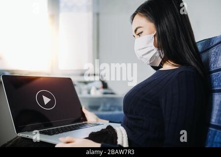 Éclosion de coronavirus : une femme qui lit des nouvelles ou des mises à jour sur le coronavirus et qui s'inquiète ou se déprime. Quarantaine à domicile pendant l'éclosion de coronavirus. Banque D'Images