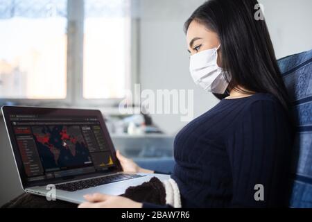 Éclosion de coronavirus : une femme qui lit des nouvelles ou des mises à jour sur le coronavirus et qui s'inquiète ou se déprime. Quarantaine à domicile pendant l'éclosion de coronavirus. Banque D'Images