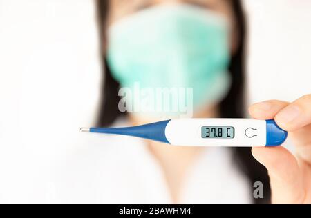 Une infirmière femme tenant un thermomètre. Concept médical de l'éclosion du virus corona. Banque D'Images