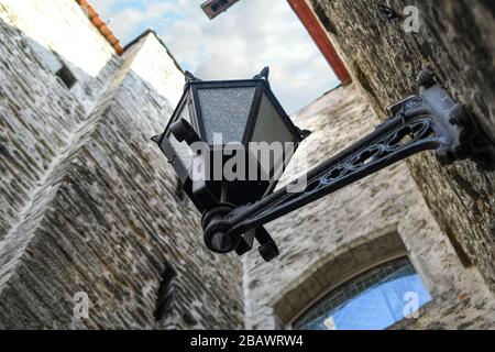 Prise de vue sélective d'une lampe de rue du XIXe siècle vue de dessous dans une ruelle médiévale étroite dans la ville de Tallinn Estonie. Banque D'Images