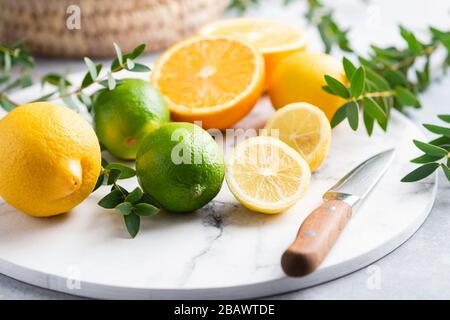 Agrumes sur planche à découper en marbre. Fruits d'été frais juteux Banque D'Images