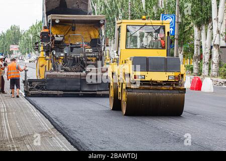 Melitopol, Ukraine, date du 27 mai 2017. La patinoire comcompacte la surface de la route, la réparation de la route dans la rue de la ville Banque D'Images