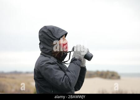 Une jeune femme blanche explorer et voyageur regarde avec des jumelles pendant la saison d'hiver Banque D'Images