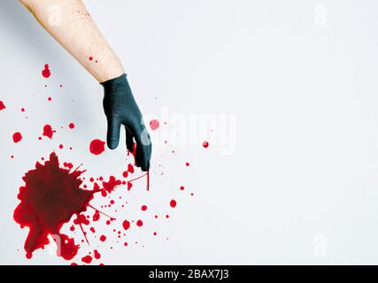 Main gantée avec éclaboussure de sang sur blanc Banque D'Images