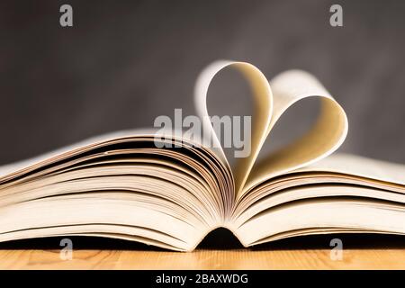 Photo de plusieurs pages d'un livre plié ensemble pour ressembler à la forme d'un coeur. Banque D'Images