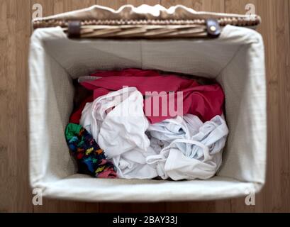 détail de l'intérieur d'un panier à linge ouvert avec différents vêtements Banque D'Images