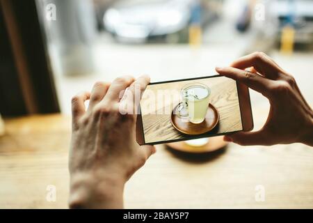 Les femmes Yang prennent une photo de thé vert avec smartphone Banque D'Images