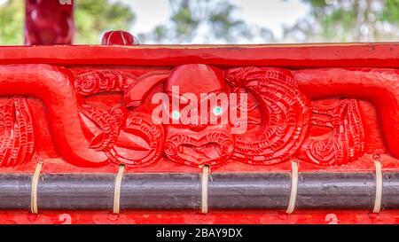 Un détail sculptant sur un canot de guerre maori (waka taua) dans le parc du Traité de Waitangi, Nouvelle-Zélande. Banque D'Images