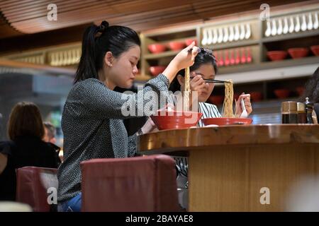 Deux femmes asiatiques profitant de rames chauds à Ippudo, Sydney NSW Banque D'Images