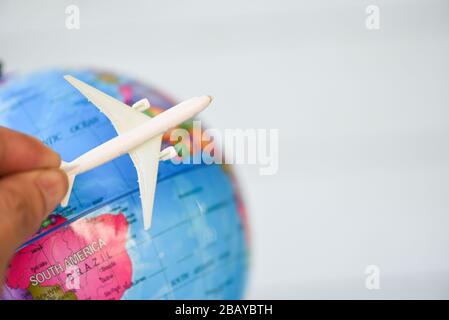 Homme d'affaires qui tient un avion de avion de ligne aérienne sur le monde entier / concept de voyage dans le monde entier Banque D'Images