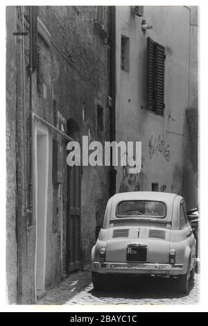 Photo de style ancien d'une Fiat Nuova 500 originale des années 1950 ou 1960 garée dans une ruelle à Trastevere, Rome, Lazio, Italie, Europe, noir et blanc Banque D'Images