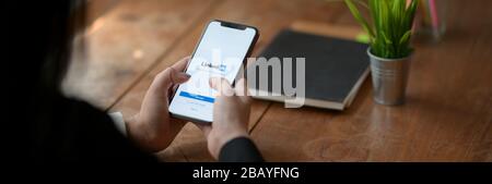 CHIANG mai, THAÏLANDE - 26 MARS 2020 : femme tenant iPhone avec écran Linkedin. LinkedIn est un réseau social pour la communauté d'affaires Banque D'Images