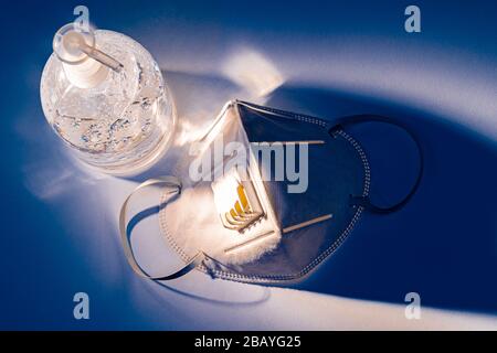 Gel anti-septique pour les mains et masque N 95 sur la table blanche avec effet d'éclairage bleu dramatique, concept de santé Banque D'Images