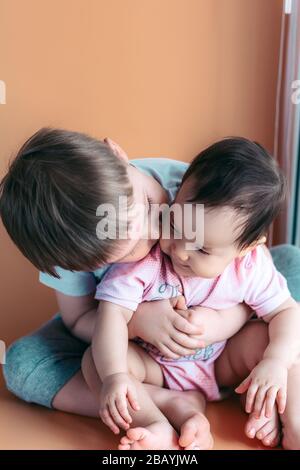 un petit frère heureux jouant hople son bébé, garçon et fille soeur embrasse les embrasses, l'amour de concept et le parentage Banque D'Images