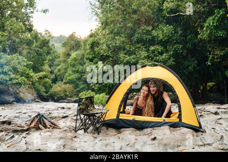 Couple d'âge mûr heureux profitant passer le week-end dans la forêt, faisant feu et se reposer dans la tente Banque D'Images