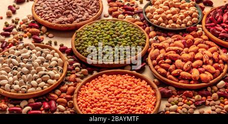 Assortiment de légumineuses sur fond brun. Lentilles, soja, pois chiches, haricots rouges, une vatiété des légumineuses Banque D'Images