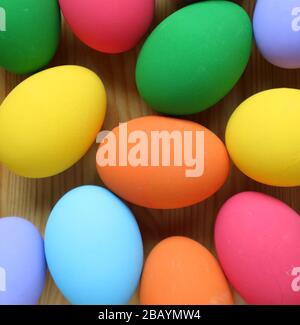 Vue de dessus des œufs de Pâques colorés dispersés sur fond en bois Banque D'Images