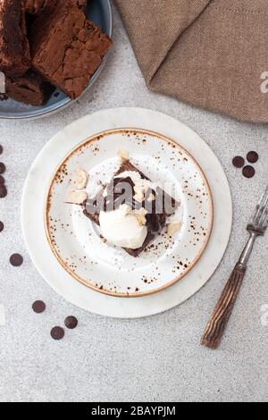 Brownie maison avec une boule de glace à la vanille, sauce au chocolat et noix Banque D'Images