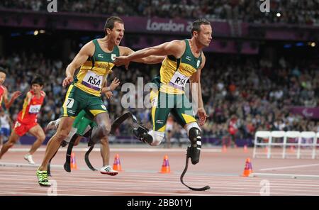 Arnu Fourie, d'Afrique du Sud, remet à Oscar Pistorius pendant les 4 x 100 m pour hommes - 4/46 le 6 jour des Jeux paralympiques de Londres 2012 au stade olympique de Londres. Banque D'Images