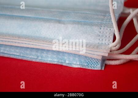 Masques médicaux sur fond rouge. La pandémie défacilité la propagation dans le monde entier. Traitement médical des personnes infectées. Santé Banque D'Images