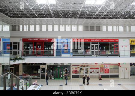 Les gens se distançant dans une file d'attente dans un centre commercial Banque D'Images