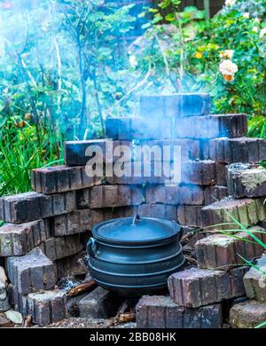 Repas extérieur traditionnel Afrikaner préparé dans un pot en fonte sur une image de feu ouvert en format vertical Banque D'Images