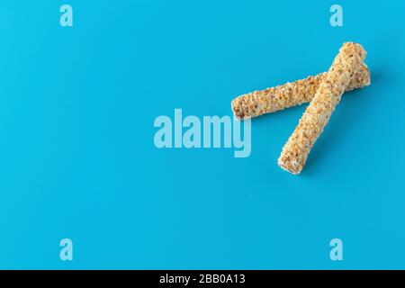 Dessert sucré sur fond bleu. Tubule avec écrous râpés. Cookies, gaufres pour le thé Banque D'Images