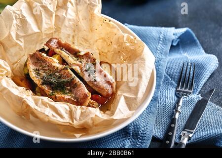 Filet de polock de poisson blanc, morue, bar de mer, bam de mer aux olives, tomates et citron, cuit en parchemin. Poisson italien traditionnel papillo avec Banque D'Images