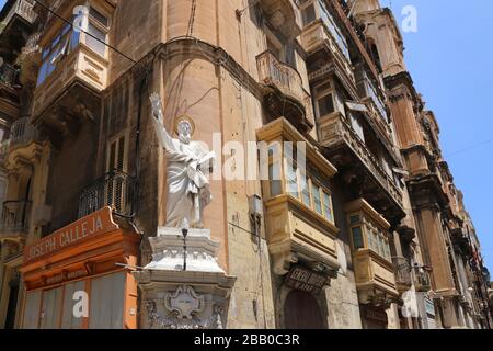 La Valette. Malte. Vieille ville. La statue de St Paul s'ériger en hauteur au coin de la rue. Banque D'Images