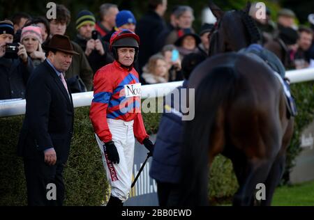 Le formateur Nicky Henderson (à gauche) se présente alors que Jockey Barry Geraghty (2ème à gauche) se prépare à monter le Sacre Sprinter avant le williamhill.com Desert Orchid Chase au deuxième jour du festival d'hiver de William Hill 2013 à l'hippodrome de Kempton Park Banque D'Images