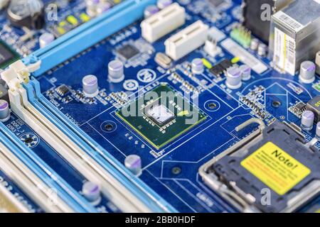 Micropuce à semi-conducteurs intégrée/microprocesseur sur carte à circuits imprimés bleue représentant de l'industrie de haute technologie et de l'informatique. Banque D'Images