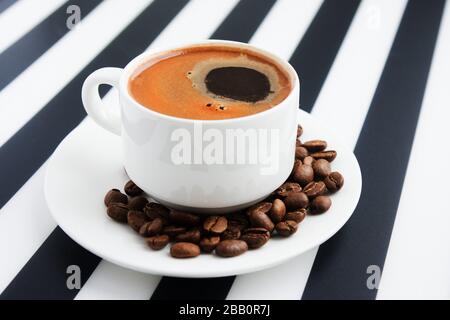 Tasse de café fort en céramique blanche sur fond rayé. Café du matin dans le minimalisme Banque D'Images