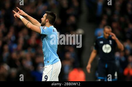 Alvaro Negredo, de Manchester City, célèbre son cinquième objectif du jeu, alors que Younes Kaboul (à droite) de Tottenham Hotspur, semble déjecté Banque D'Images