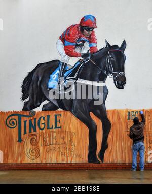L'artiste Graffiti Olivier Roubieu applique les touches de finition à sa fresque murale du festival de Noël de Sandown's Tingle Creek pendant la journée du gentleman Banque D'Images