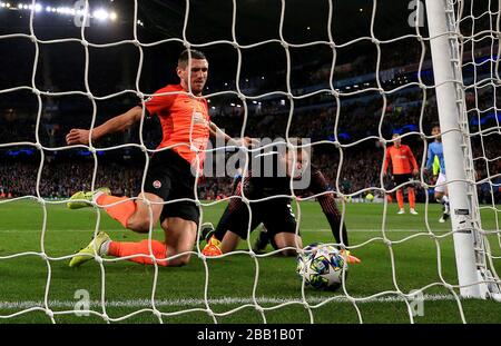 Le Sergiy Kryvtsov de Shakhtar Donetsk se retire de la ligne après que le gardien de but Andrei Pyatov renverse le ballon Banque D'Images