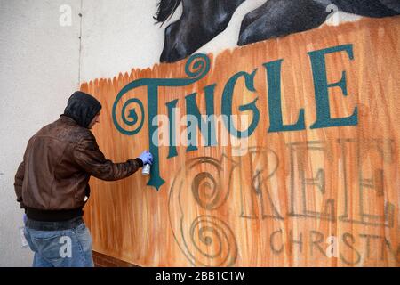 L'artiste Graffiti Olivier Roubieu applique les touches de finition à sa fresque murale du festival de Noël de Sandown's Tingle Creek pendant la journée du gentleman Banque D'Images