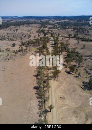 Aérien d'une route de campagne non scellée passant par la sécheresse a affecté la région de pâturage des bovins près du mont Perry Queensland Australie Banque D'Images