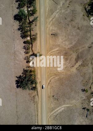 Aérien d'une route de campagne non scellée passant par la sécheresse a affecté la région de pâturage des bovins près du mont Perry Queensland Australie Banque D'Images