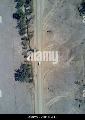 Aérien d'une route de campagne non scellée passant par la sécheresse a affecté la région de pâturage des bovins près du mont Perry Queensland Australie Banque D'Images