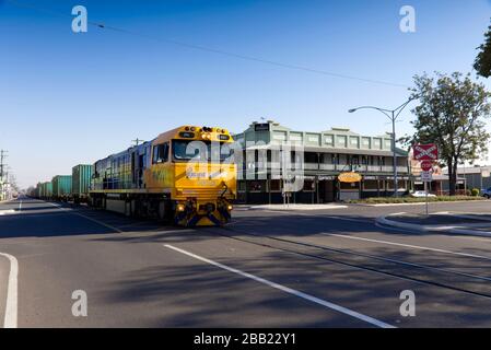 Pacific National Freight train qui passe devant un hôtel de style queenslander à Rockhampton Queensland Australie Banque D'Images