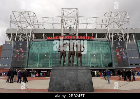 On peut voir une vue générale sur Old Trafford, la statue de la Trinité unie des anciens joueurs George Best, Denis Law et Bobby Charlton Banque D'Images