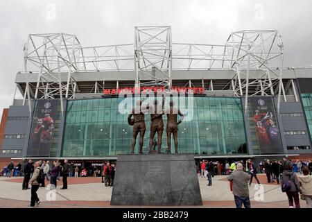 On peut voir une vue générale sur Old Trafford, la statue de la Trinité unie des anciens joueurs George Best, Denis Law et Bobby Charlton Banque D'Images