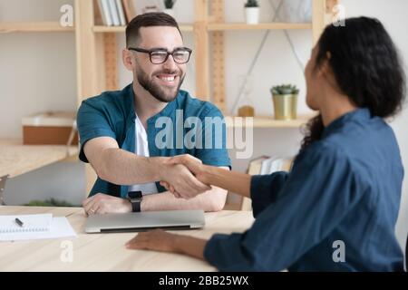 Sourire employeur homme poignée de main femme candidat à l'emploi à la réunion Banque D'Images