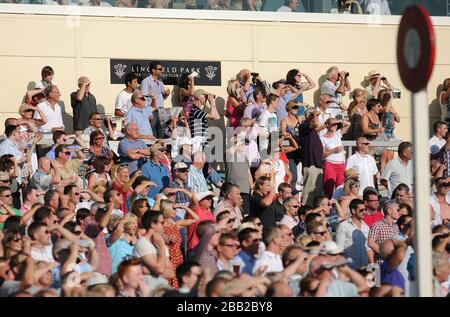 Une foule pleine de monde au parc de Lingfield profitant du soleil. Banque D'Images