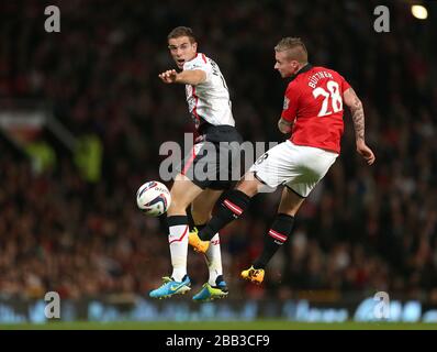 Le Jordan Henderson de Liverpool (à gauche) et le Manchester United's Alexander Buttner se battent pour le ballon dans les airs Banque D'Images