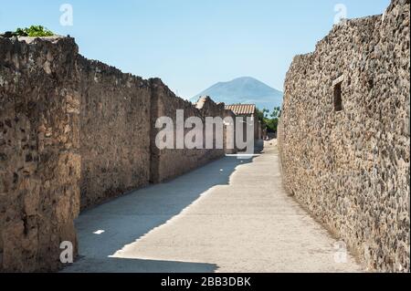 Ancienne rue avec le Vésuve en arrière-plan, dans l'ancienne ville de Pompéi, en Italie Banque D'Images