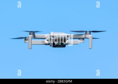 Drone Quadcopter pendant le vol une journée ensoleillée sur fond bleu ciel Banque D'Images