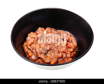 cuisine géorgienne - portion de lobio (apéritif épicé à base de haricots cuits) dans un bol noir isolé sur fond blanc Banque D'Images