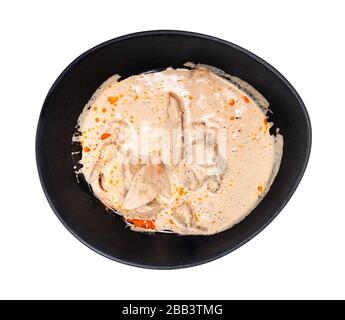 Cuisine géorgienne - vue de dessus de Satsivi (apéritif froid épicé de poulet en sauce aux noix) dans un bol noir isolé sur fond blanc Banque D'Images