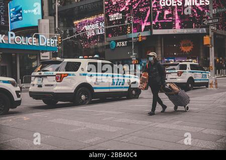 Femme portant un masque tout en marchant dans la rue à New York Banque D'Images